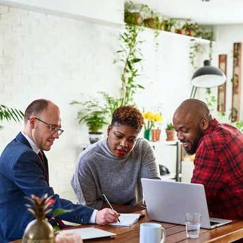 Couple listening to financial advisor at home with laptop