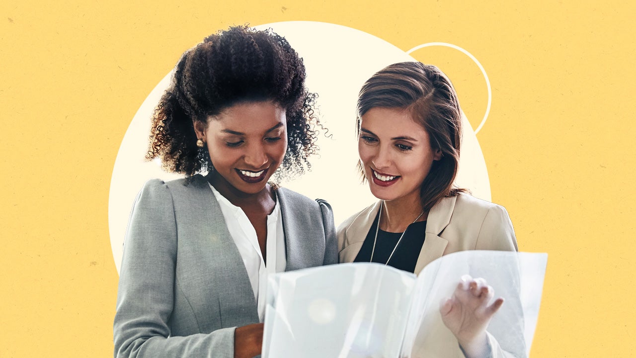 Two women look at documents.